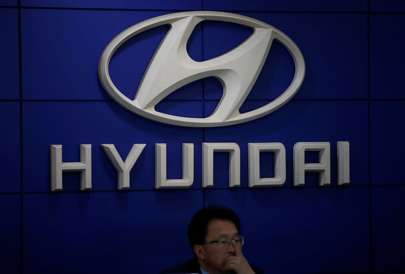 An employee sits in front of the logo of Hyundai Motor at its dealership in Seoul, South Korea October 26, 2016. REUTERS/Kim Hong-Ji