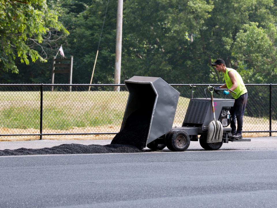 Peter Carlton, of Syracuse, New York, lays down rubber for the new all-weather track for Rakuten Co. on June 29 at the new Morgan High School football field. The facility will open for the first time this fall, which includes a new football field, press box, bleachers, locker rooms and track.