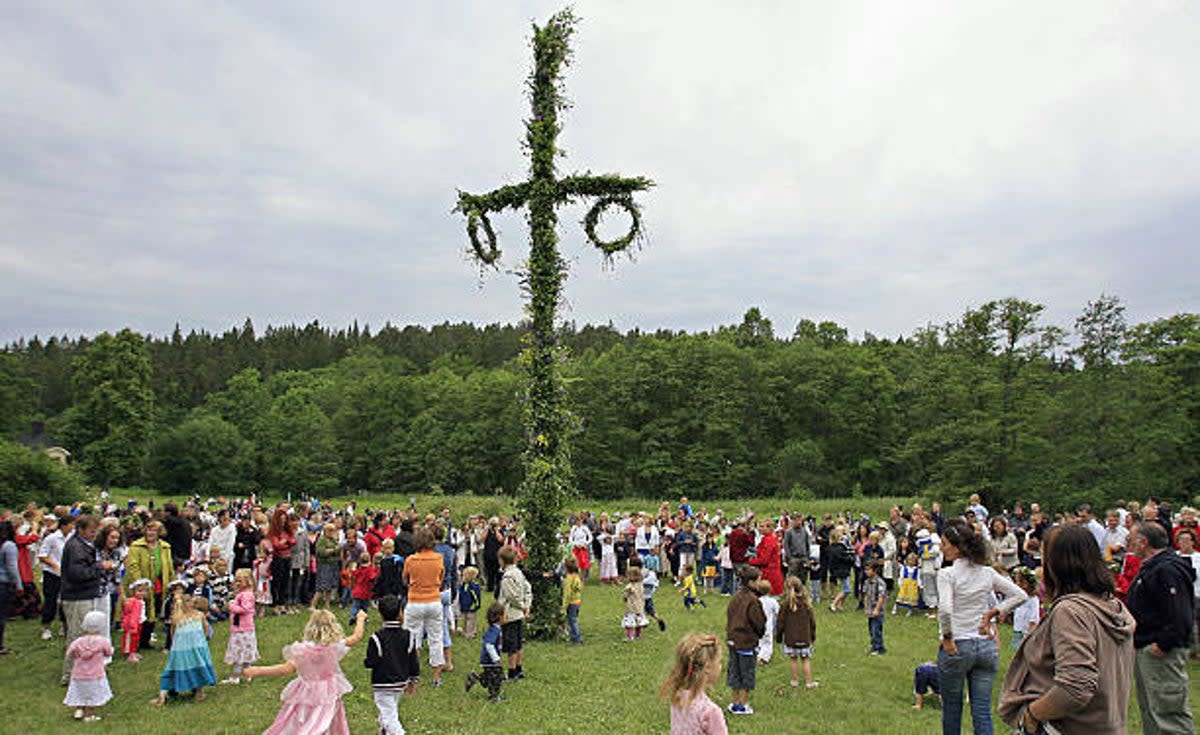 Swedish people celebrate Midsommar by dancing around a maypole   (Sven Nackstrand / AFP via Getty Images)