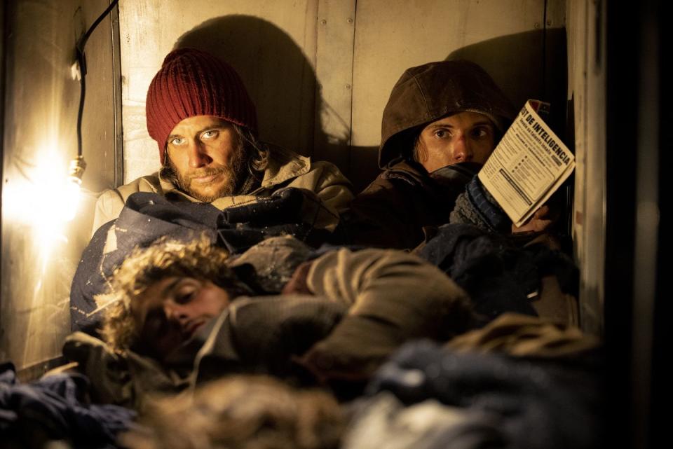 survivors huddled together inside an airplane in a scene from society of the snow