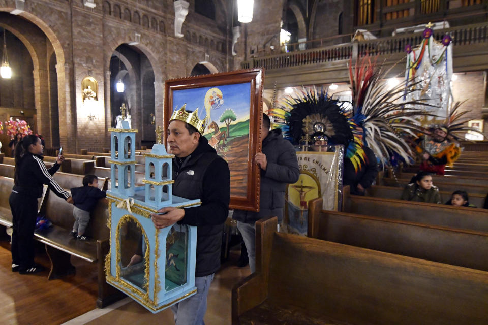 In this Jan. 24, 2020 photo, steward Apolinar Morales leads a procession with a shrine representing the church of St. Paul inside the Sagrado Corazon de Jesus church in Minneapolis. Morales and others held a two-day celebration for St. Paul, the patron saint of their Mexican hometown of Axochiapan and nearby villages in the state of Morelos. (AP Photo/Jim Mone)