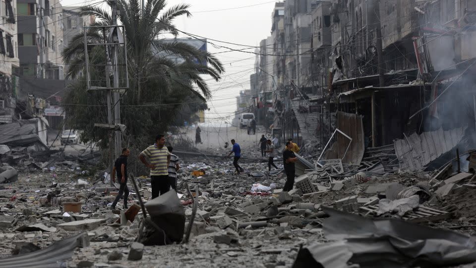 Palestinians inspect the damage of destroyed buildings following Israeli airstrikes on Gaza City on Friday. - Abed Khaled/AP