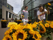 Visitors leaving the reopened Van Gogh Museum were offered a free sunflower in Amsterdam, Netherlands, Monday, June 1, 2020. The Dutch government took a major step to relax the coronavirus lockdown, with bars, restaurants, cinemas and museums reopening under strict conditions. (AP Photo/Peter Dejong)