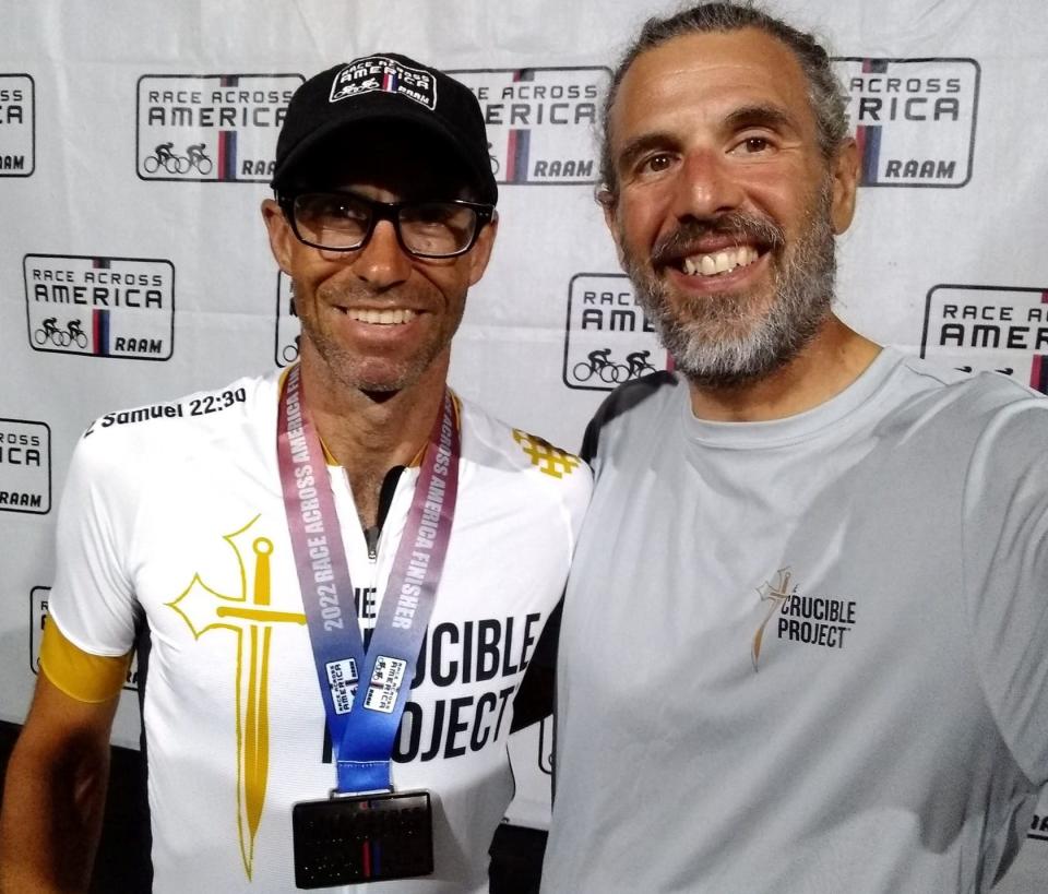 Les Crooks of Mishawaka, left, wears his medal at the finish of the Race Across America with his trainer, prior RAAM racer Giovanni Prosperi, on June 26, 2022.