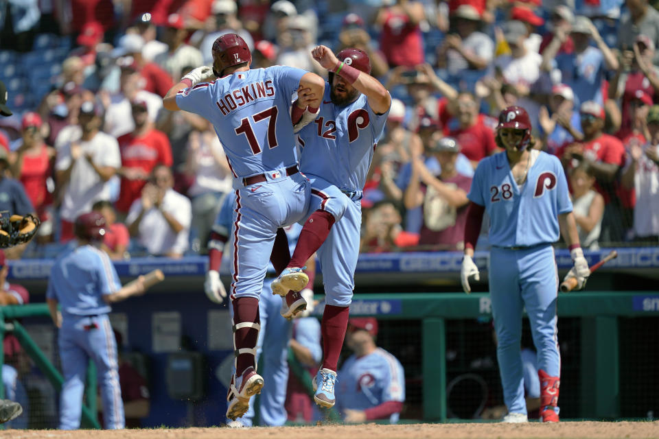 Philadelphia Phillies' Rhys Hoskins (17) celebrates with Kyle Schwarber after hitting a two-run home run off of Washington Nationals relief pitcher Cory Abbott during the fourth inning of a baseball game, Sunday, Aug. 7, 2022, in Philadelphia. (AP Photo/Matt Rourke)