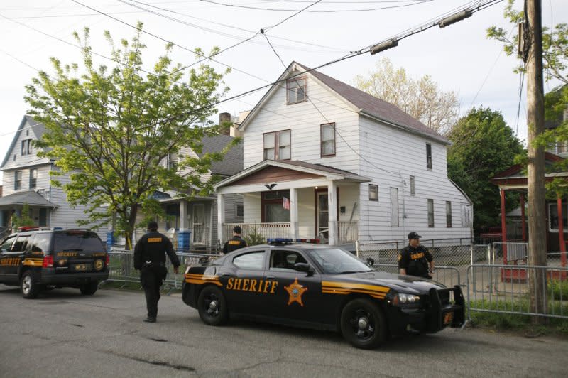Law enforcement officers stand watch in front of a house on Seymour Avenue in Cleveland where Amanda Berry, Gina DeJesus and Michelle Knight were found alive May 6, 2013, after having been held hostage for nearly 10 years. File Photo by David Maxwell/EPA
