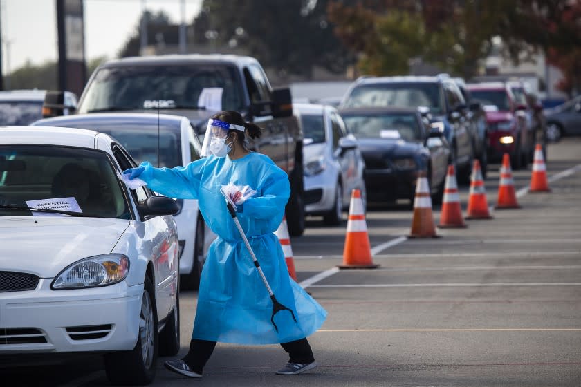 A 360 Clinic health care worker conducts testing at a drive-through site in Costa Mesa.