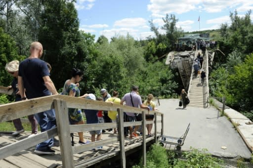 Those wanting to cross the bridge at Stanytsya Luganska have to walk the kilometre to the other side, while elderly people and those with disabilities have to pay to be taken in a wheelchair�