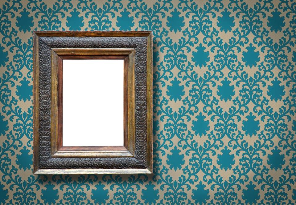 mirror in frame on wall with turquoise patterned wallpaper