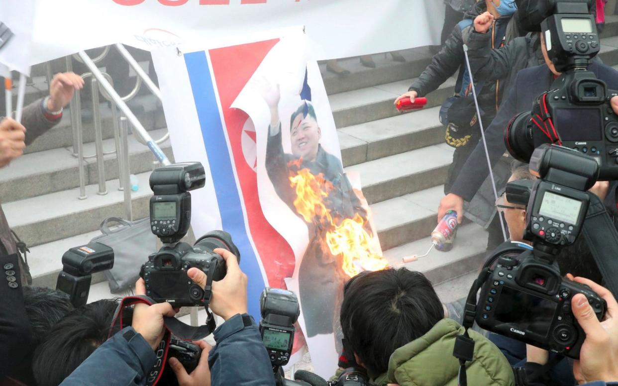 Protesters burn an image of Kim Jong-un in Seoul - AFP