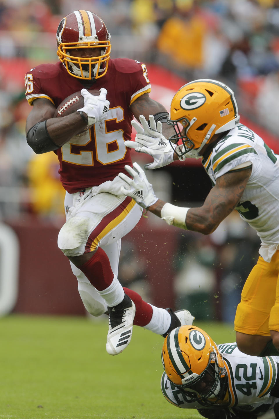 Washington Redskins running back Adrian Peterson (26) carries the ball past Green Bay Packers cornerback Jaire Alexander (23) during the first half of an NFL football game, Sunday, Sept. 23, 2018, in Landover, Md. (AP Photo/Carolyn Kaster)