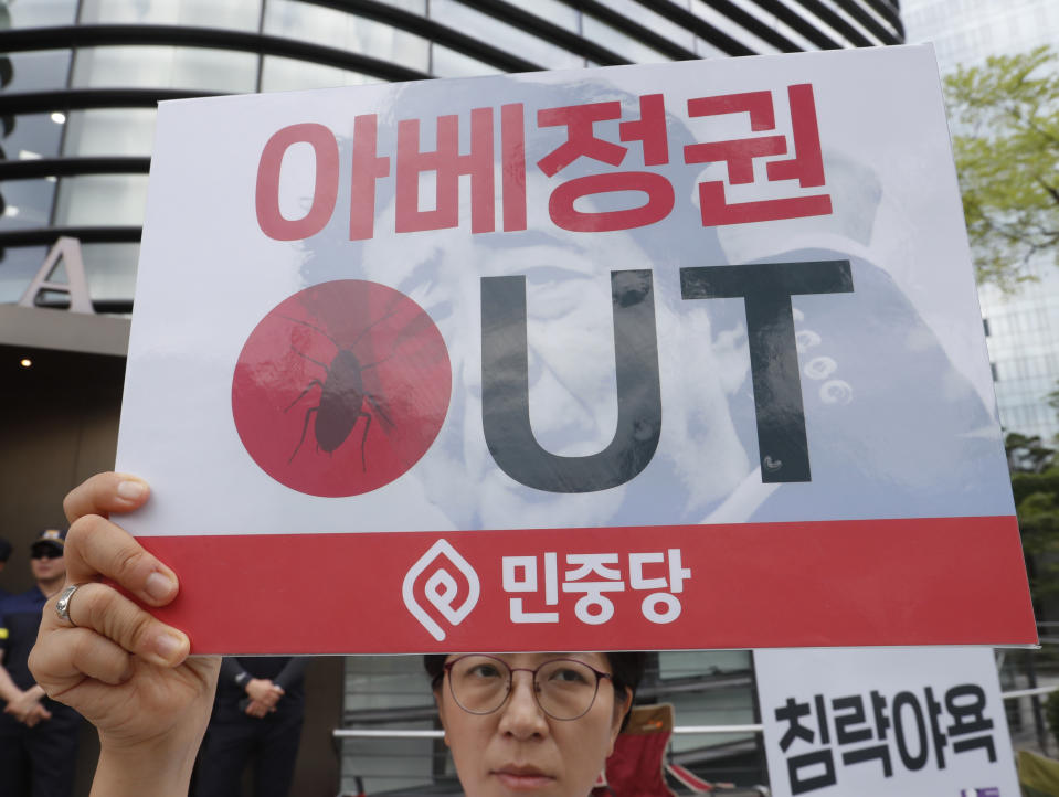 A South Korean protester holds up a banner to denouncing the Japanese government's decision on their exports to South Korea in front of the Japanese embassy in Seoul, South Korea, Friday, Aug. 2, 2019. Japan's Cabinet on Friday approved the removal of South Korea from a "whitelist" of countries with preferential trade status, a move sure to fuel antagonism already at a boiling point over recent export controls and the issue of compensation for wartime Korean laborers. The signs read: "The government of Japanese Prime Minister Shinzo Abe." (AP Photo/Ahn Young-joon)