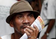 A gambler watches horse racing on television in Malabon, Metro Manila, Philippines March 21, 2015. Horseracing is one of the more popular forms of sports betting, both legal and illegal, in the Philippines. When paying your final respects for a relative or friend, the last thing you might expect to see at the wake is people placing bets on a card game or bingo. Not in the Philippines. Filipinos, like many Asians, love their gambling. But making wagers on games such as "sakla", the local version of Spanish tarot cards, is particularly common at wakes because the family of the deceased gets a share of the winnings to help cover funeral expenses. Authorities have sought to regulate betting but illegal games persist, with men and women, rich and poor, betting on anything from cockfighting to the Basque hard-rubber ball game of jai-alai, basketball to spider races. Many told Reuters photographer Erik De Castro that gambling is only an entertaining diversion in a country where two-fifths of the population live on $2 a day. But he found that some gamble every day. Casino security personnel told of customers begging to be banned from the premises, while a financier who lends gamblers money at high interest described the dozens of vehicles and wads of land titles given as collateral by those hoping lady luck would bring them riches. REUTERS/Erik De Castro PICTURE 27 OF 29 FOR WIDER IMAGE STORY "HIGH STAKES IN MANILA". SEARCH "BINGO ERIK" FOR ALL IMAGES.