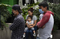 A woman sits with her son outside home as they wait until it is called safe to return to their apartment, after an earthquake in Mexico City, Tuesday, June 23, 2020. The earthquake struck near the Huatulco resort in southern Mexico on Tuesday morning, swayed buildings in Mexico City and sent thousands fleeing into the streets. (AP Photo/Marco Ugarte)