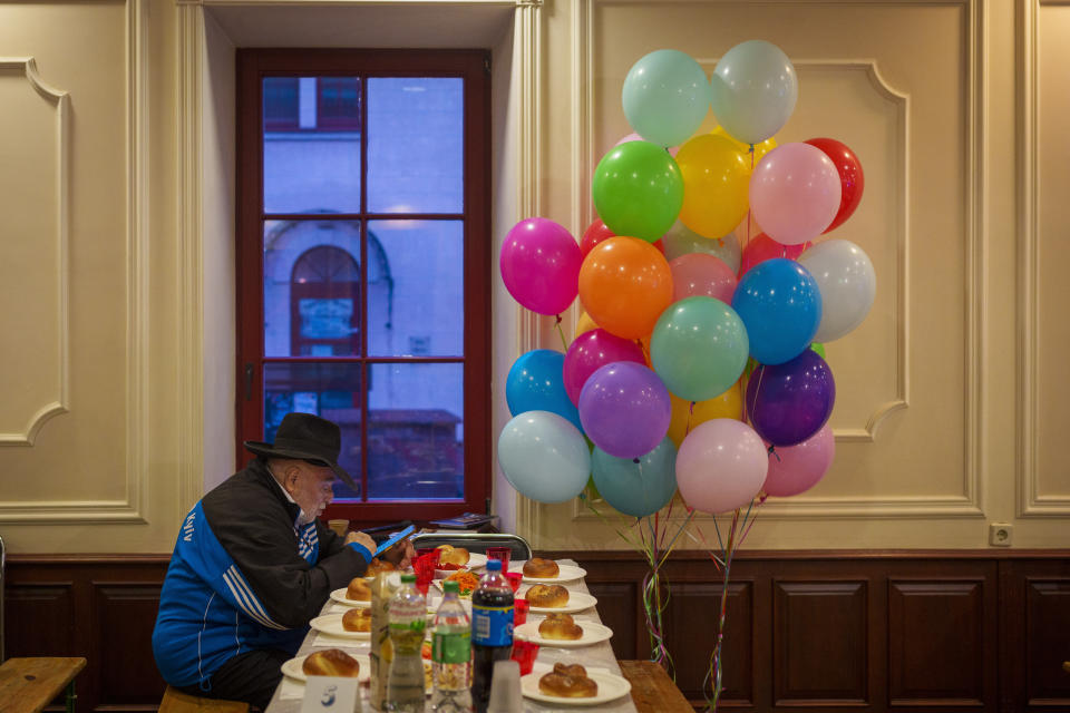 A man of the Ukrainian Jewish community looks at a mobile phone before Purim celebrations and a festive meal at the Great Choral Synagogue in Kyiv, Ukraine, Sunday, March 24, 2024. (AP Photo/Vadim Ghirda)