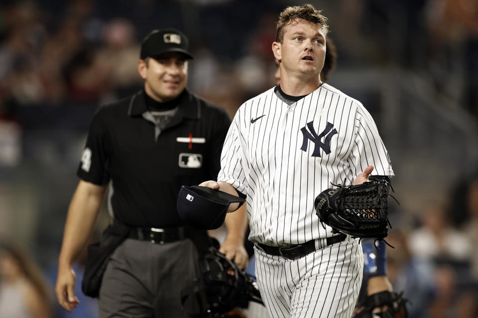 New York Yankees relief pitcher Justin Wilson holds out his hat and glove after they were checked by umpires during the fourth inning of the team's baseball game against the Los Angeles Angels on Wednesday, June 30, 2021, in New York. (AP Photo/Adam Hunger)