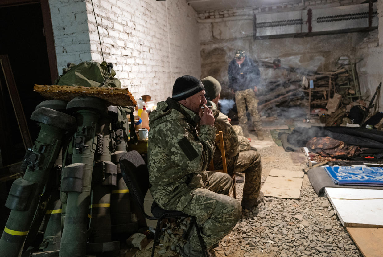 Militares del Batallón Sich de los Cárpatos del Ejército ucraniano fuman cigarrillos en una base subterránea en la región de Járkov, en Ucrania, mientras esperan el cese del fuego de artillería en su posición, el miércoles 11 de mayo de 2022. (Lynsey Addario/The New York Times)
