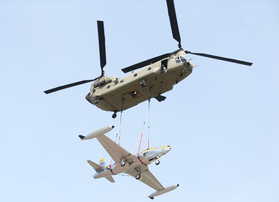 An Army CH-47 Chinook helicopter carries the historic F-80 fighter jet from Sioux City to Camp Dodge for display at the camp Tuesday, April 11, 2023, in Johnston, Iowa.