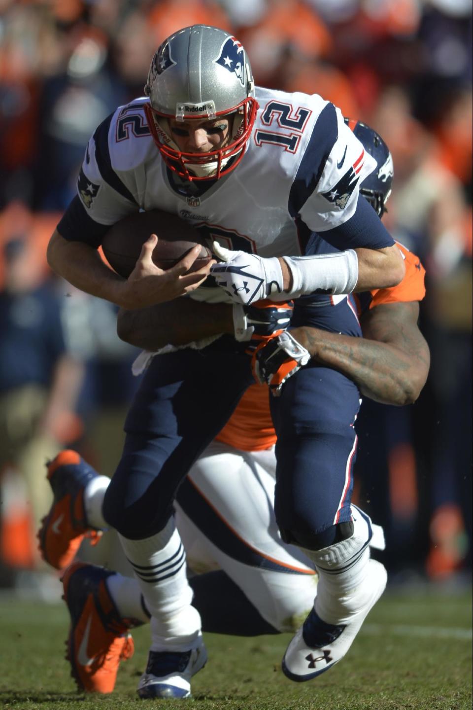 New England Patriots quarterback Tom Brady (12) is sacked by Denver Broncos defensive end Robert Ayers (91) during the first half of the AFC Championship NFL playoff football game in Denver, Sunday, Jan. 19, 2014. (AP Photo/Jack Dempsey)