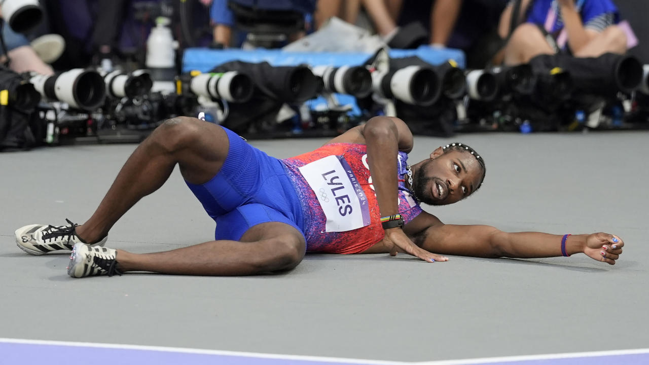 Noah Lyles, of the United States, lays on the track after the men's 200-meter final at the 2024 Summer Olympics, Thursday, Aug. 8, 2024, in Saint-Denis, France. (AP Photo/Matthias Schrader)