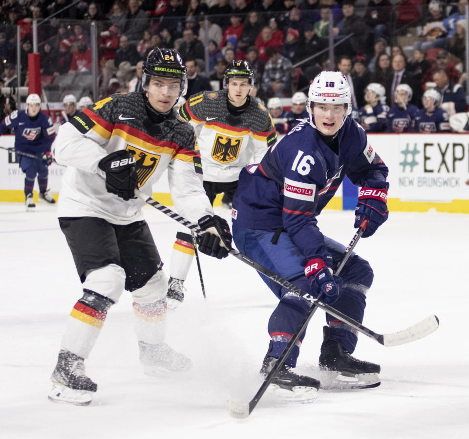 Germany's Roman Kechter, left, and United States' Chaz Lucius wait for a pass from the corner during second-period IIHF world junior hockey championships quarterfinal match action in Moncton, New Brunswick, Monday, Jan. 2, 2023. (Ron Ward/The Canadian Press via AP)