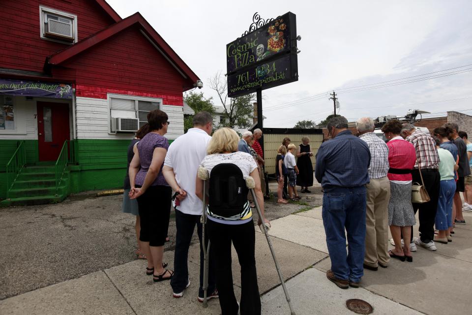 People gather outside Cosmic Pizza in Hartwell in 2013 for a vigil in memory of the restaurant's owner Richard Evans, who was fatally shot during a robbery.