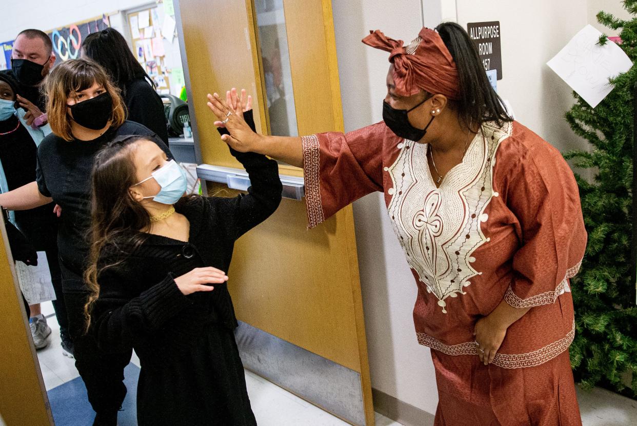 Erica Austin high fives the fifth grade students who presented a Kwanzaa celebration at Enos Elementary School in Springfield, Ill., Wednesday, December 22, 2021. [Justin L. Fowler/The State Journal-Register] 