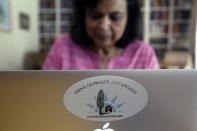 Ranjana Bhandari, executive director of Liveable Arlington, works on a laptop at her home in Arlington, Texas, on Tuesday, Oct. 26, 2021. More than a decade ago, Bhandari and her neighbors convinced an oil and gas company to locate a natural gas drill site farther away from their homes. Now she is helping residents in other Arlington neighborhoods, particularly those with fewer resources, to do the same. She has taken particular aim at TEP Barnett, a subsidiary of French energy giant Total Energies, which has 33 well sites in Arlington and more in neighboring communities. (AP Photo/Martha Irvine)