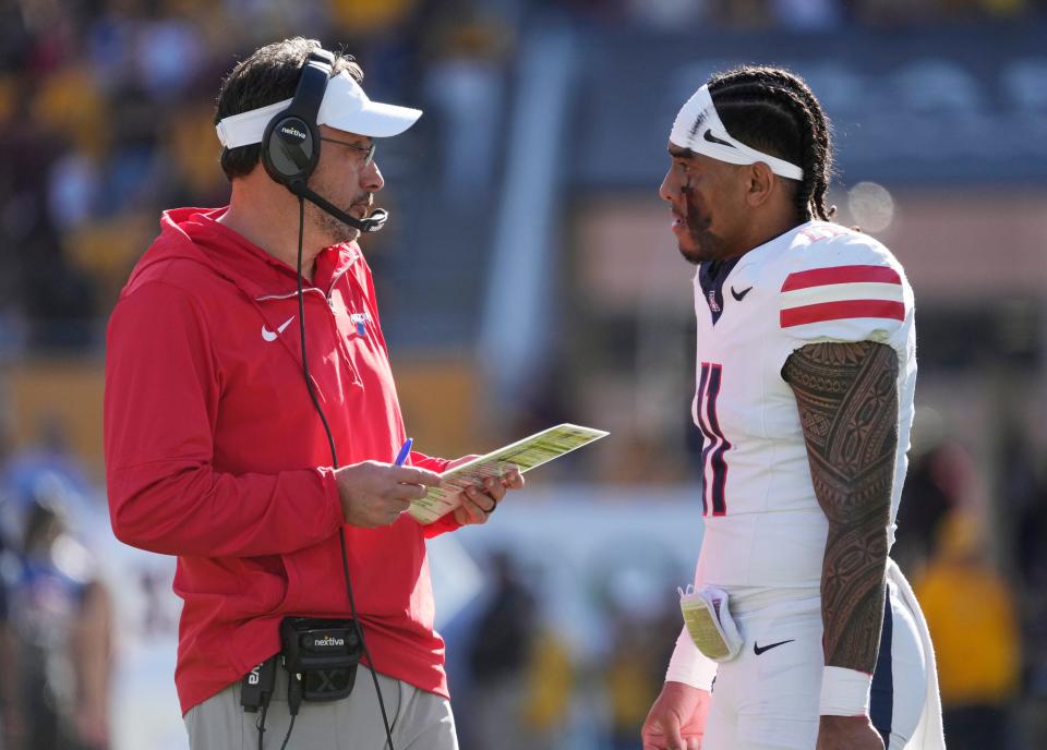 Arizona head coach Jedd Fisch talks with quarterback Noah Fifita (11) during the first quarter against Arizona State at Mountain America Stadium in Tempe on Nov. 25, 2023.