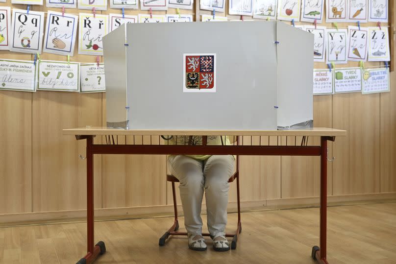 A woman prepares her ballots for the European Parliament elections at a polling station in Prague, Czech Republic, Friday, June 7, 2024