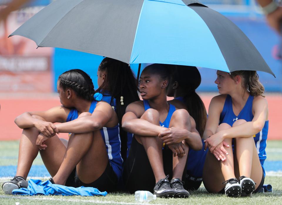 Members of the Sussex Central entry in the Division II 4x200 meter relay seek refuge from the sun as they wait for their heat on the second and final day of the DIAA state high school track and field championships Saturday, May 22, 2021 at Dover High School.