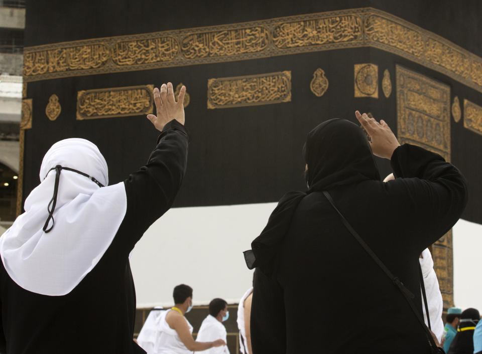 Muslim pilgrims pray in front of the Kaaba, the cubic building at the Grand Mosque, as they wear masks and keep social distancing, a day before the annual hajj pilgrimage, Saturday, July 17, 2021. The pilgrimage to Mecca required once in a lifetime of every Muslim who can afford it and is physically able to make it, used to draw more than 2 million people. But for a second straight year it has been curtailed due to the coronavirus with only vaccinated people in Saudi Arabia able to participate. (AP Photo/Amr Nabil)