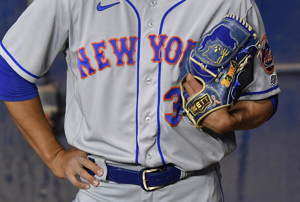 New York Mets starting pitcher Kodai Senga's glove features a ghost and a fork as he stands in the bullpen before a baseball game against the Miami Marlins, Sunday, April 2, 2023, in Miami. (AP Photo/Michael Laughlin)