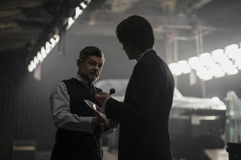 This image released by Warner Bros. Pictures shows Andy Serkis, left, and Robert Pattinson in a scene from "The Batman." (Jonathan Olley/Warner Bros. Pictures via AP)