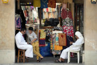 Shop staff wait for customers in front of a souvenir shop at the Souq Waqif Market in Doha, Qatar, Friday, Nov. 25, 2022. (AP Photo/Eugene Hoshiko)