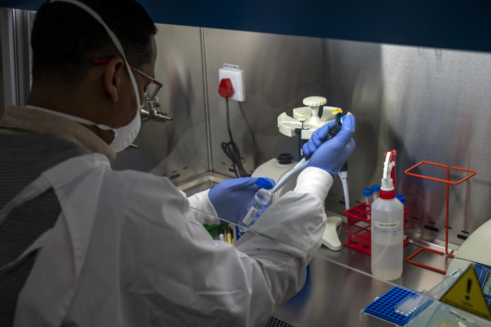 FILE - In this May 21, 2020, file photo, a lab technician performs Covid-19 testing at a clinic in the Moutse Valley, 160 kms (100 miles) north east of Johannesburg, South Africa. Africa’s confirmed coronavirus cases have surpassed 1 million, but global health experts tell The Associated Press the true toll is several times higher. (AP Photo/Jerome Delay, File)