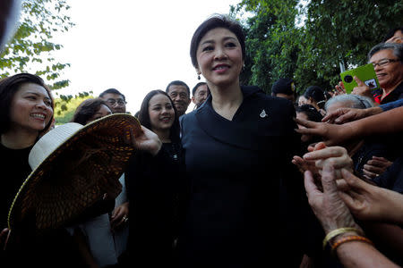 Ousted former Thai Prime Minister Yingluck Shinawatra greets supporters as she arrives at the Supreme Court for a trial on criminal negligence looking into her role in a debt-ridden rice subsidy scheme during her administration, in Bangkok, Thailand December 9, 2016. REUTERS/Chaiwat Subprasom