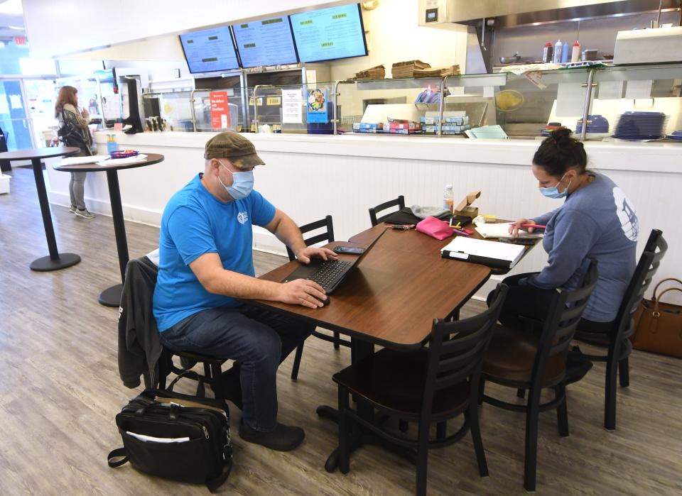 Tony Di Norcia, left, owner of Beach Bagels, sits with general manager Alycia Marshall, while looking over applicants at the Monkey Junction location in Wilmington, N.C., Tuesday, January 11, 2022. Di Norcia has had trouble finding staffing at his four Wilmington locations. [MATT BORN/STARNEWS]