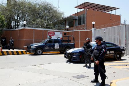 Police officers guard the entrance of the Coca-Cola FEMSA distribution plant after it closes down due to the issues of security and violence during the campaign rally of Independent presidential candidate Margarita Zavala (unseen) in Ciudad Altamirano in Guerrero state, Mexico April 3, 2018. REUTERS/Ginnette Riquelme/Files