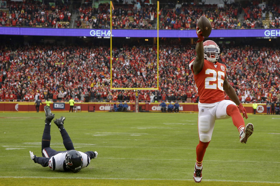 Kansas City Chiefs running back Damien Williams (26) scores a touchdown ahead of Houston Texans linebacker Jacob Martin (54) during the first half of an NFL divisional playoff football game, in Kansas City, Mo., Sunday, Jan. 12, 2020. (AP Photo/Charlie Riedel)