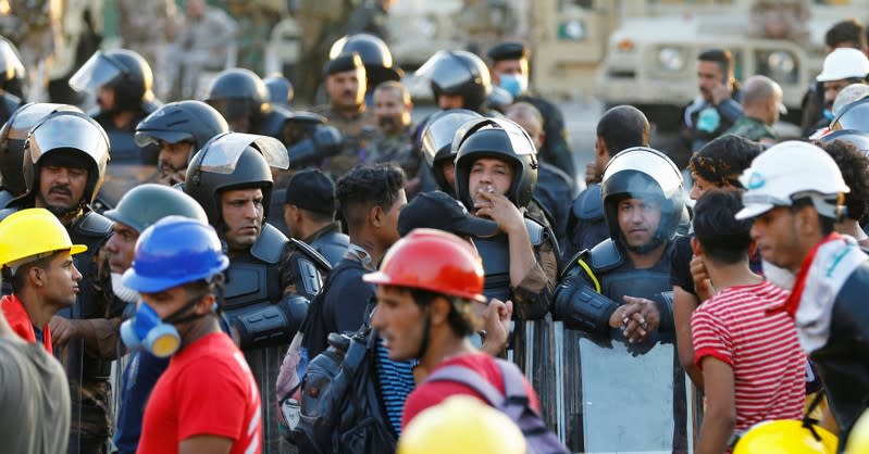 Riot police stand at Al Shuhada bridge during ongoing anti-government protests, in Baghdad