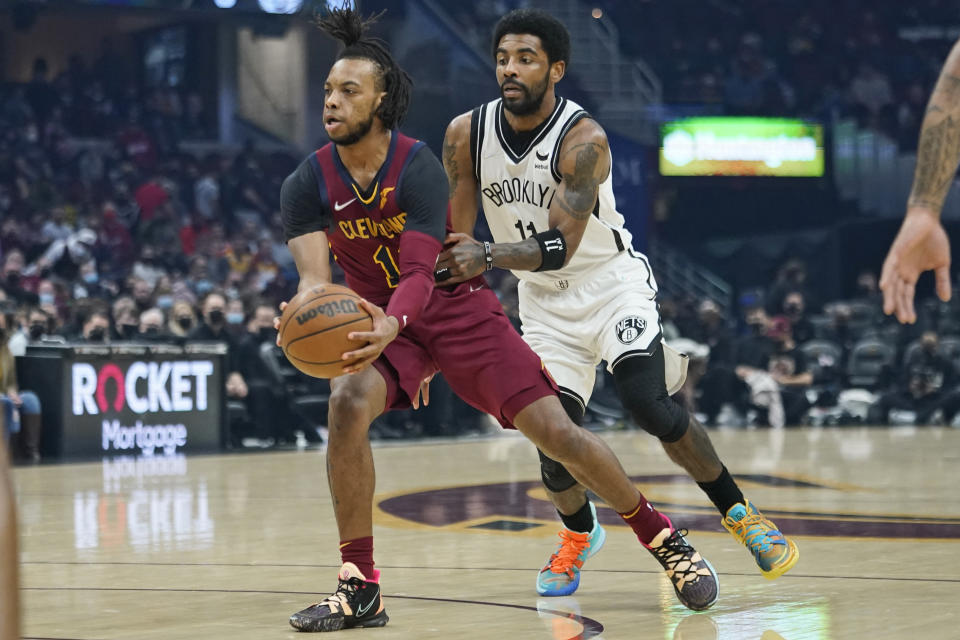 Cleveland Cavaliers' Darius Garland, left, drives against Brooklyn Nets' Kyrie Irving (11) in the first half of an NBA basketball game, Monday, Jan. 17, 2022, in Cleveland. (AP Photo/Tony Dejak)