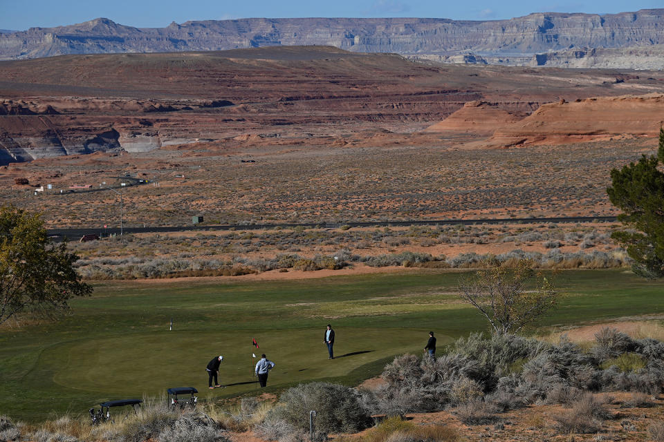 PAGE, AZ - OCTOBER 23: People play golf on the Lake Powell National Golf Course near the Colorado River on October 23, 2022 in Page, Arizona. The water in Lake Powell and the Colorado River has been receding due to recent droughts leaving parts of the lake and river parched. The federal government are moving forward with plans to reduce water allocations from the Colorado River Basin to Arizona and is asking millions of residents to reduce their water consumption as the drought get worse. (Photo by Joshua Lott/The Washington Post via Getty Images)
