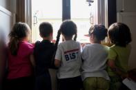 Children pose by a window inside a nursery of Cartigliano