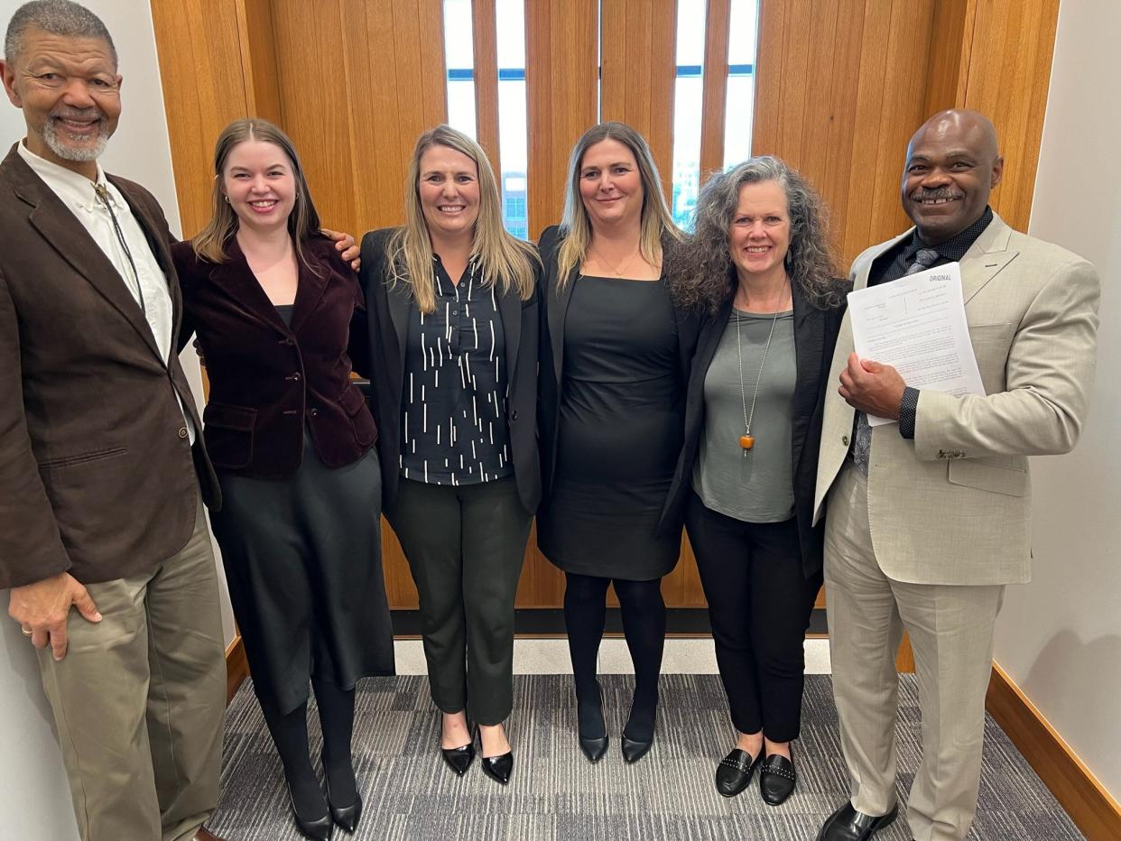 Johnny McMiller, right, a former Austin police lieutenant, holds the verdict after a jury this week awarded him $1.5 million in a lawsuit he filed alleging racial discrimination and retaliation by the Police Department.