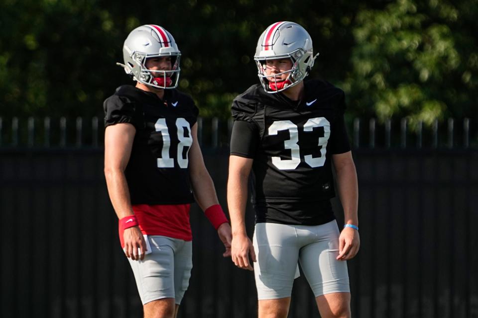 Aug 1, 2024; Columbus, OH, USA; Ohio State Buckeyes quarterback Devin Brown (33) and quarterback Will Howard (18) take snaps during football camp at the Woody Hayes Athletic Complex.