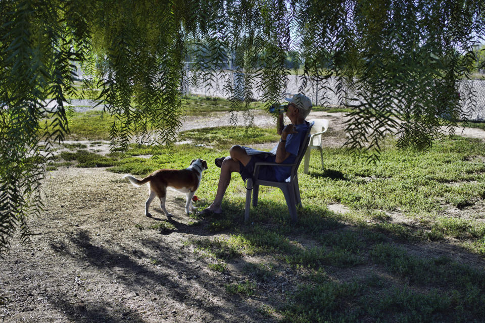 A man sits with his dog and hydrates in the shade in an attempt to beat the heat in Los Angeles on Thursday, July 13, 2023. After a historically wet winter and a cloudy spring, California's summer is in full swing. A heat wave that's been scorching much of the U.S. Southwest is bringing triple digit temperatures and an increased risk of wildfires. (AP Photo/Richard Vogel)