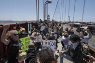 People take a knee while marching on the Golden Gate Bridge in San Francisco, Saturday, June 6, 2020, at a protest over the Memorial Day death of George Floyd. Floyd died May 25 after being restrained by Minneapolis police. (AP Photo/Jeff Chiu)