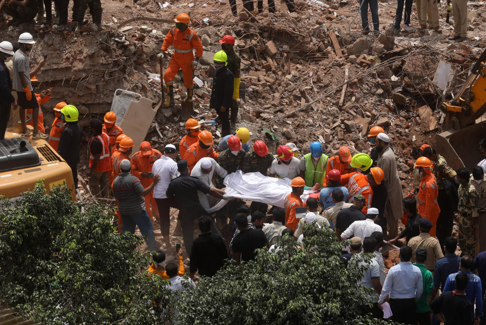 Indian rescue workers search for people in the rubble of a collapsed five-storey apartment building in Mahad. (Photo by Imtiyaz Shaikh/Anadolu Agency via Getty Images)