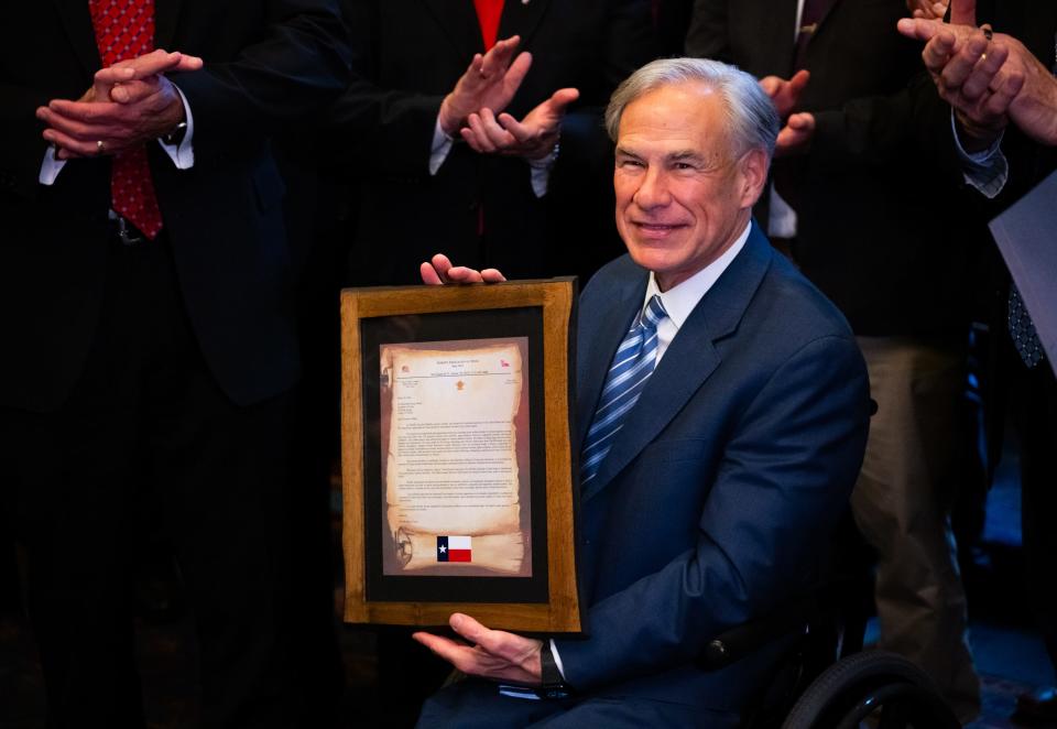 Gov. Greg Abbott displays a letter from more than 100 Texas sheriffs.
